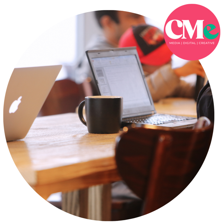 Two people working with their mac laptops open and black cups of coffee