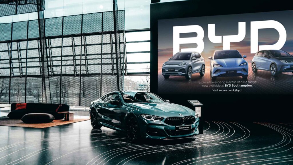 Digital screens in a car showroom running a CMe Automotive campaign