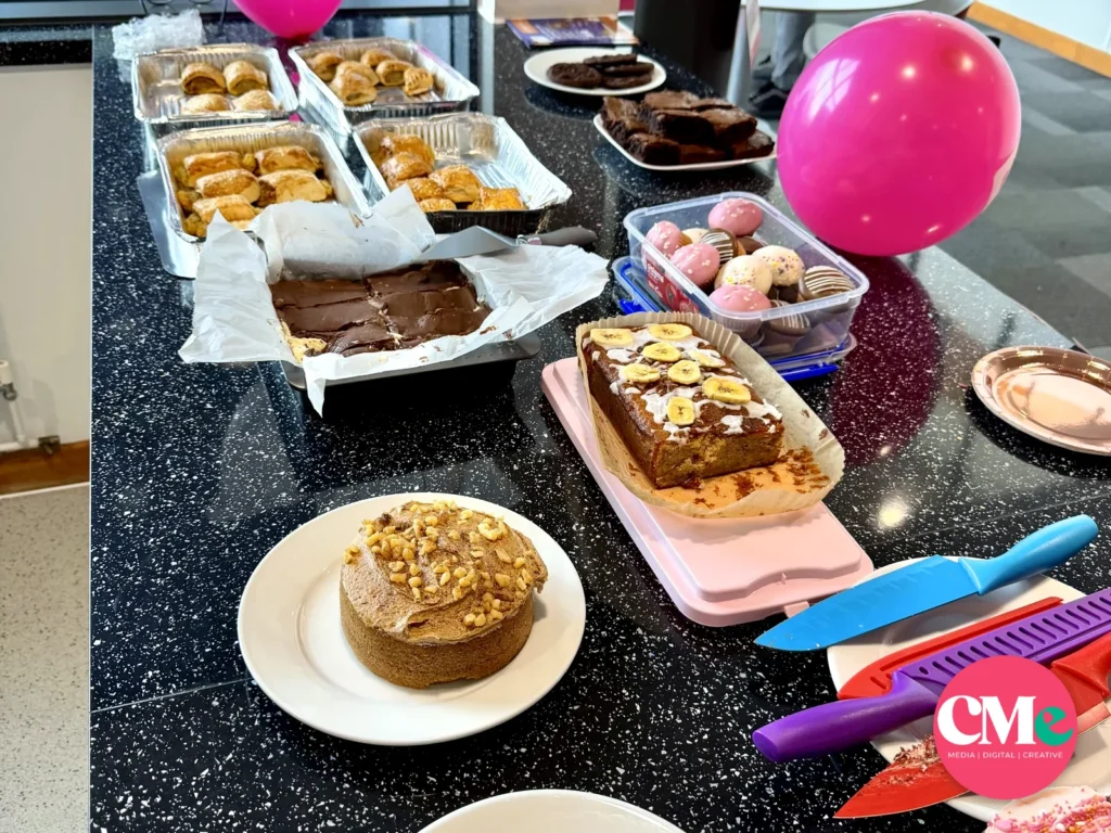 Sausage rolls, brownies, banana bread, cakes and cupcakes laid out at the CMe Media charity bake sale