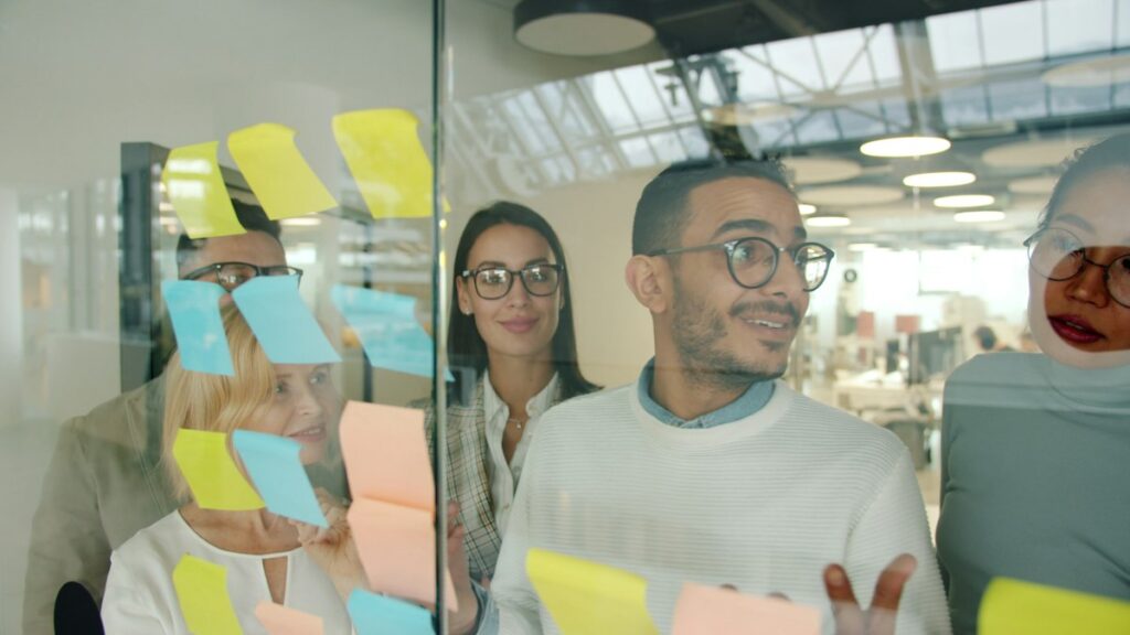 Team brainstorming a content strategy with sticky notes on glass