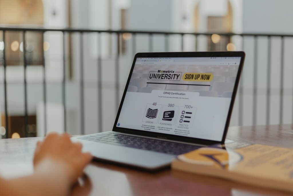 Person editing website content on a laptop at a wooden table