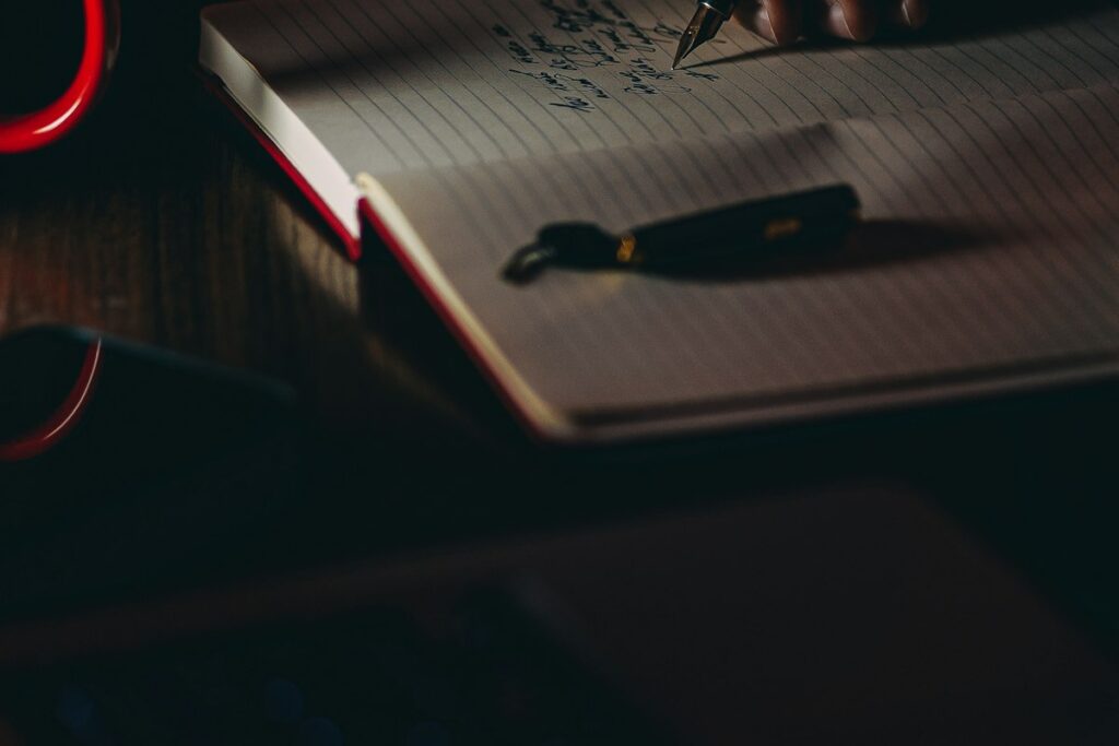 Person writing copy by hand in a notebook