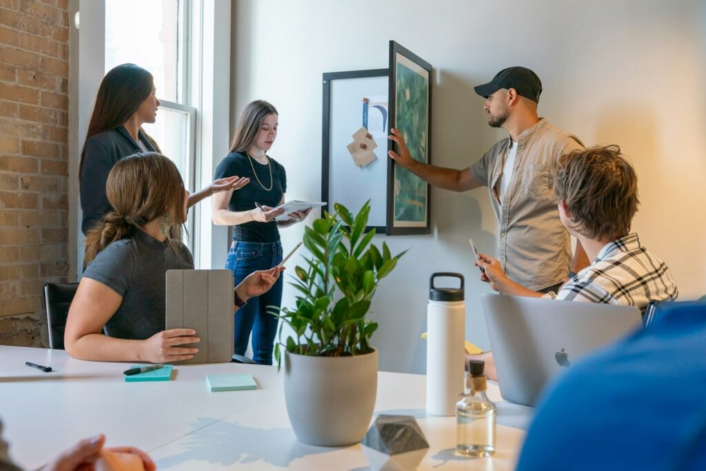 Creative team gathered around a table reviewing designs