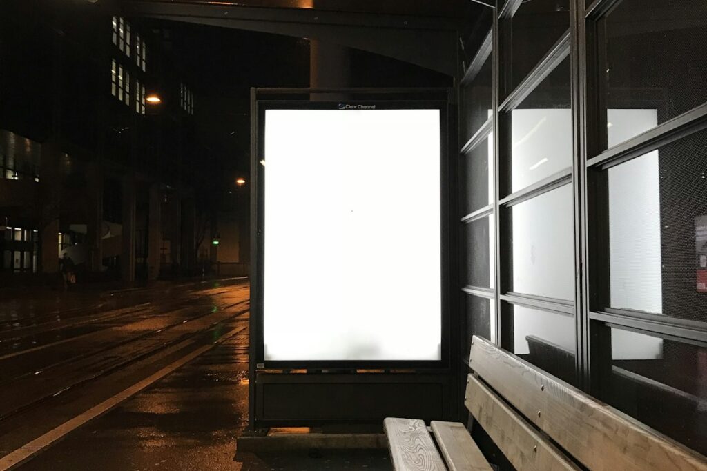 Illuminated advertising billboard at a bus stop at night