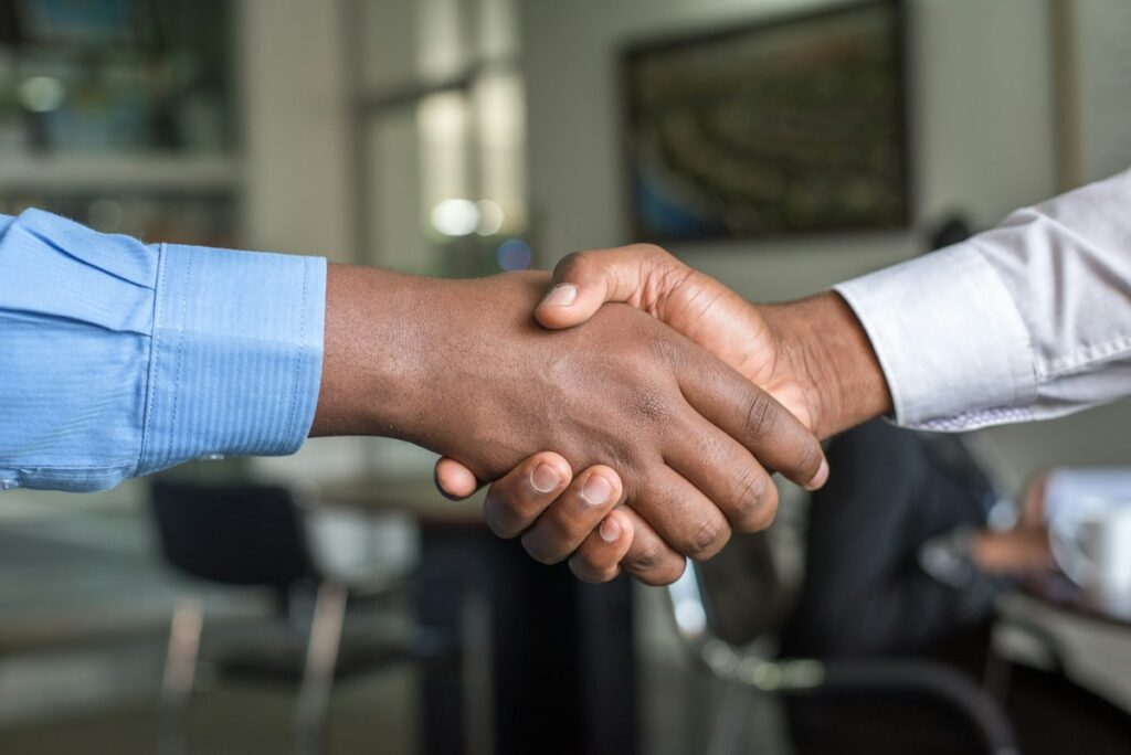 Two business professionals shaking hands, representing trust and authority