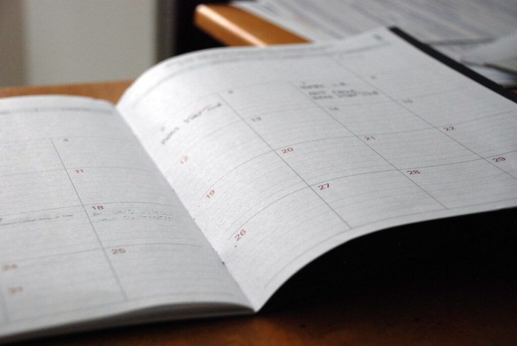 Open monthly planner on a wooden desk for content calendar planning