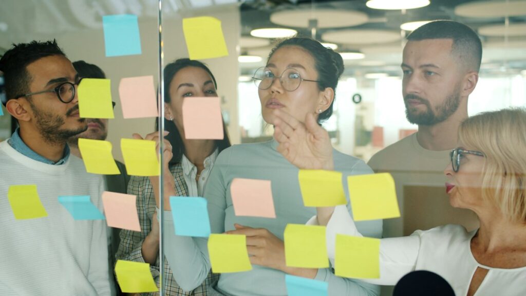 Creative team collaborating on sticky notes in a modern office