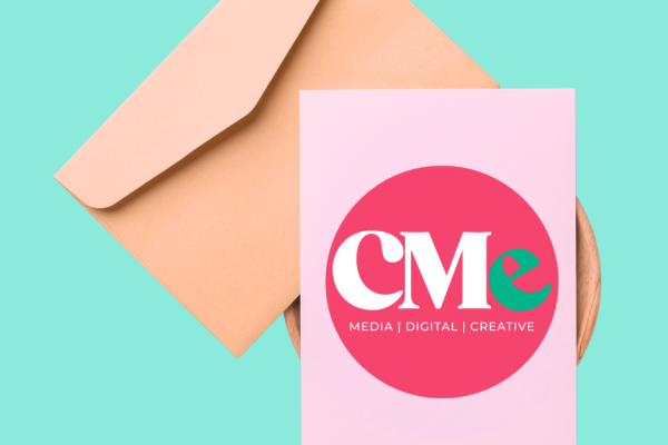 A brown envelope with a card placed on top with the CMe Media logo on the card
