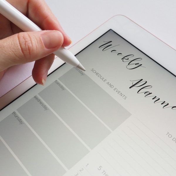 a person writing a weekly planner, on a digital tablet